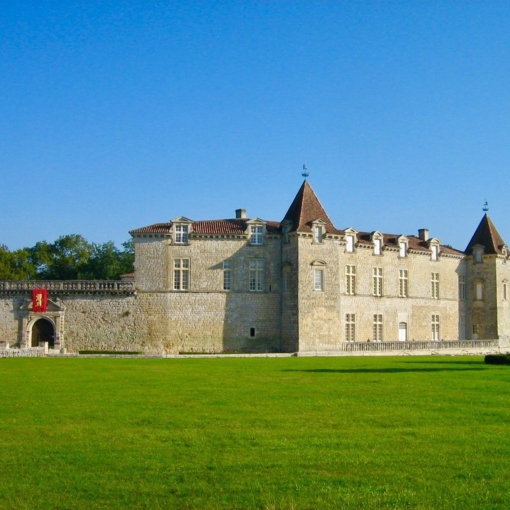 Château de Cazeneuve à Préchac en Gironde sous un ciel bleu au cœur du parc verdoyant