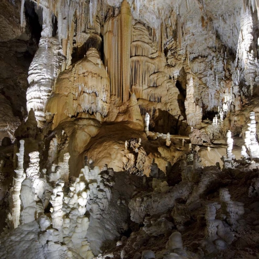 Spectaculaires concrétions de calcite et stalagmites illuminées dans la Grotte de Clamouse à Saint-Jean-de-Fos.