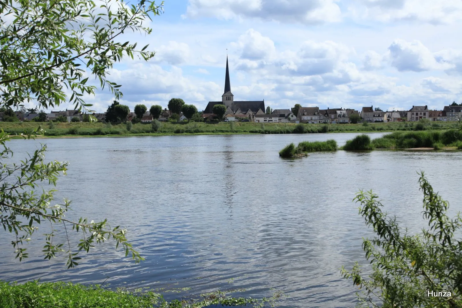Vue de Sully-sur-Loire depuis les bords de Loire, avec l’église Saint-Germain et les maisons de la ville en arrière-plan.