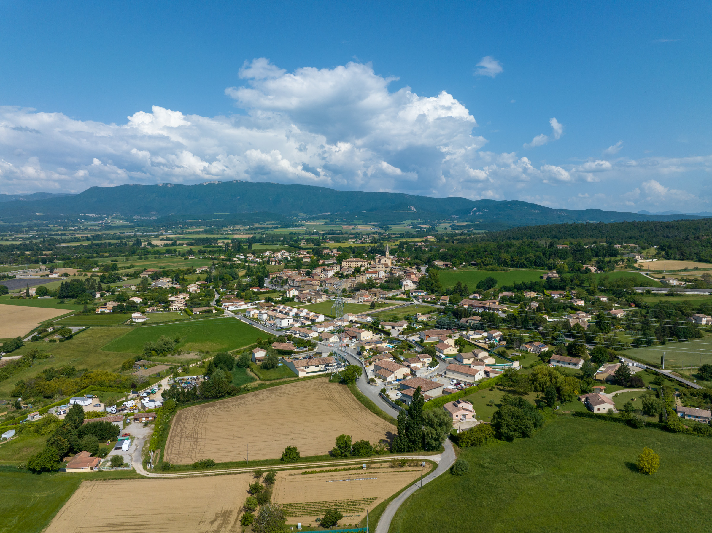 Vue aérienne d’Upie entourée de champs avec le Vercors en arrière-plan