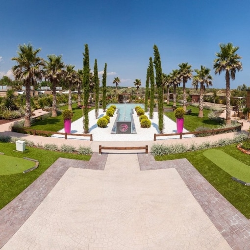 Vue panoramique du jardin méditerranéen du Centre Naturiste René Oltra au Cap d’Agde sous un ciel bleu et ensoleillé