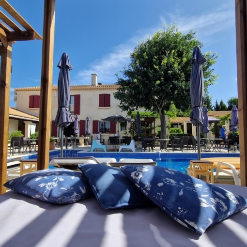Espace détente au bord de la piscine de l’Hôtel Le Mas des Amandiers à Graveson.