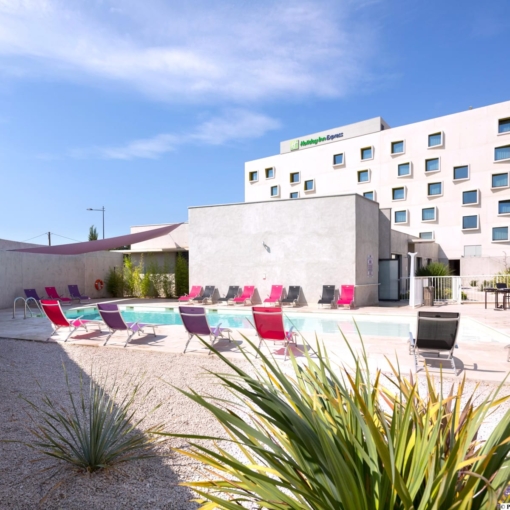 Piscine extérieure avec transats colorés à l’hôtel Holiday Inn Express.