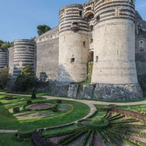 Vue extérieure du Château d’Angers et de ses jardins à la française sous un ciel bleu en Anjou