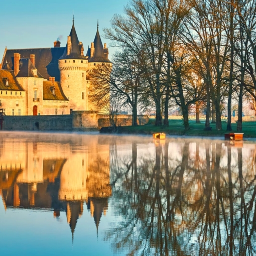 Reflet du Château de Sully-sur-Loire dans les eaux calmes au lever du soleil.