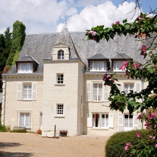Façade du Manoir de La Giraudière à Beaumont-en-Véron, demeure de charme typiquement tourangelle entourée de verdure et de fleurs