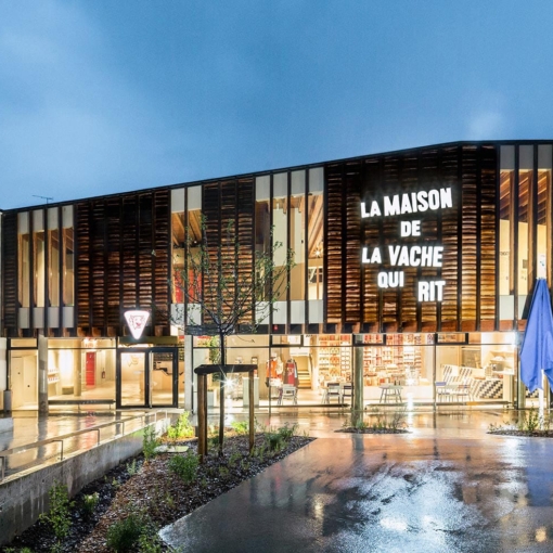 Façade illuminée de La Maison de La Vache qui Rit à Lons-le-Saunier.