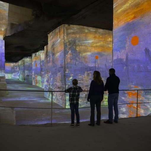 Famille admirant une projection immersive dans les Carrières des Lumières aux Baux-de-Provence