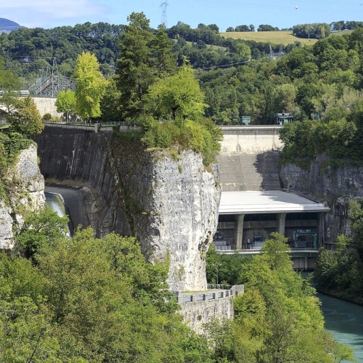 Vue sur le barrage-centrale de Génissiat à Injoux-Génissiat, ouvrage hydroélectrique sur le Rhône entouré de verdure