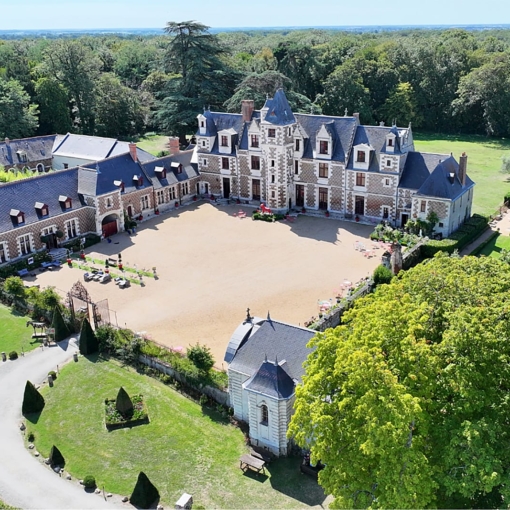 Château de Vayres en Gironde vu depuis ses jardins à la française sous un ciel bleu