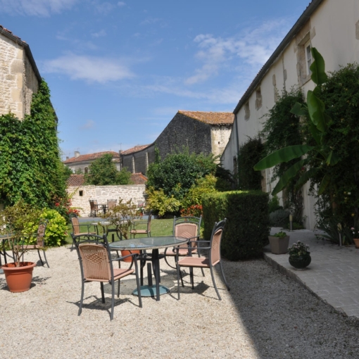 Cour intérieure verdoyante de l’Hôtel du Donjon à Aulnay.