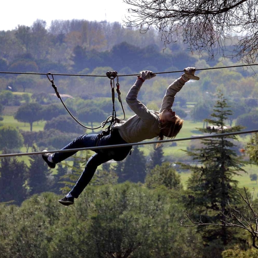 Participant en plein effort sur un parcours accrobranche à Agd’Aventure, parc de loisirs en plein air à Agde, idéal pour sensations fortes et activités nature en famille ou entre amis