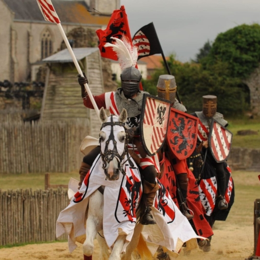 Chevaliers en armure lors d’une reconstitution médiévale au château de Tiffauges, cavaliers et chevaux décorés de bannières colorées