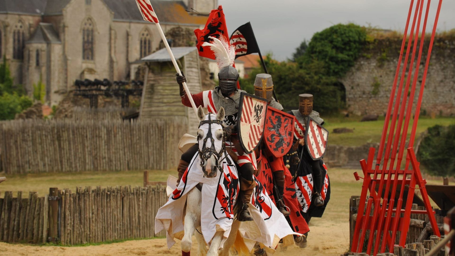 Chevaliers en armure lors d’une reconstitution médiévale au château de Tiffauges, cavaliers et chevaux décorés de bannières colorées