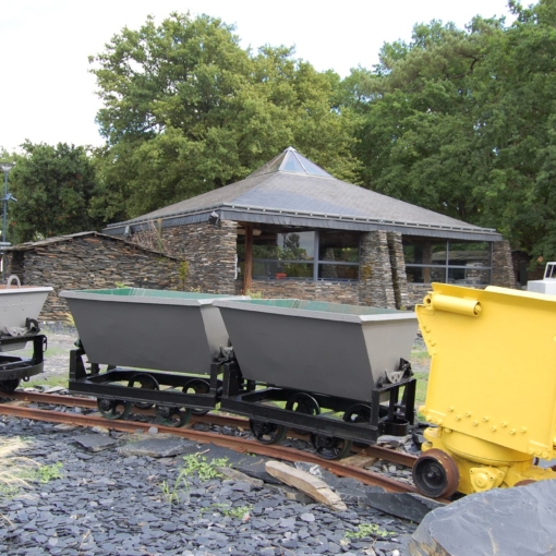 Outils et machines traditionnelles d’ardoisiers exposés sous un abri au Musée de l’Ardoise