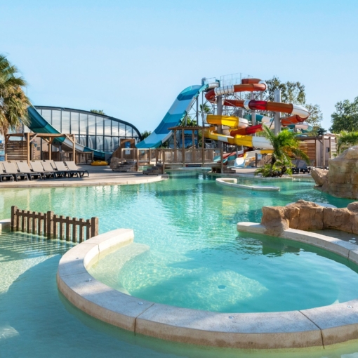 Parc aquatique du Camping Club Les Tamaris au Barcarès, avec piscines, toboggans et palmiers.